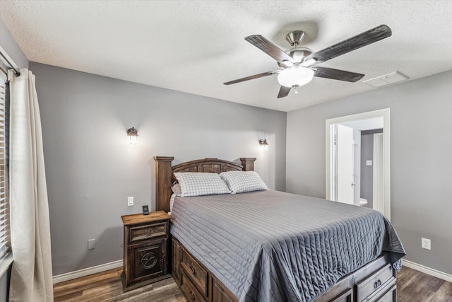 bedroom featuring a ceiling fan, a textured ceiling, visible vents, dark wood finished floors, and baseboards