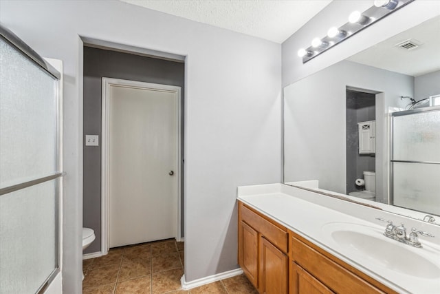 bathroom with visible vents, vanity, toilet, and a shower stall