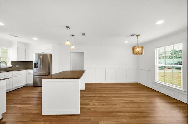 kitchen with visible vents, stainless steel fridge, a sink, and a healthy amount of sunlight
