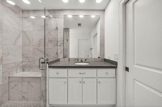 bathroom with visible vents, a marble finish shower, recessed lighting, and vanity