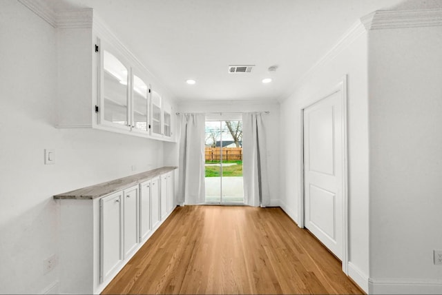 unfurnished dining area with recessed lighting, visible vents, ornamental molding, baseboards, and light wood-style flooring