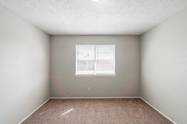 carpeted spare room with baseboards and a textured ceiling