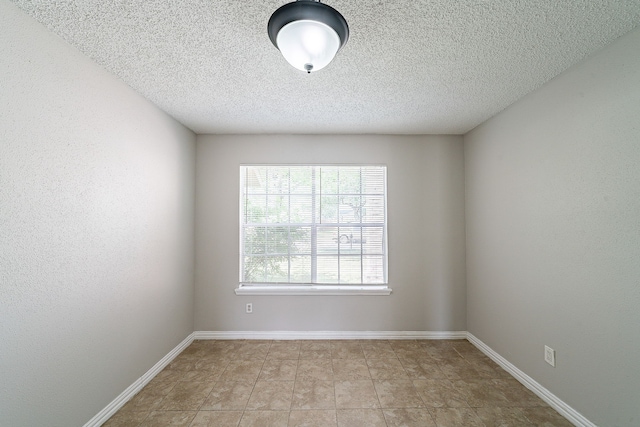 unfurnished room featuring baseboards and a textured ceiling