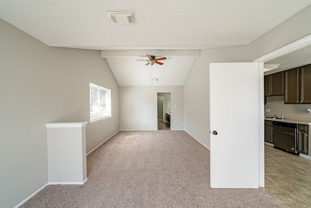 empty room with ceiling fan, vaulted ceiling, light colored carpet, and visible vents