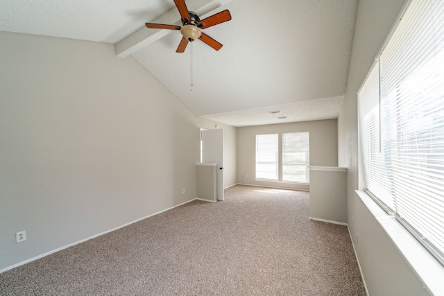 empty room with ceiling fan, a textured ceiling, baseboards, lofted ceiling with beams, and light carpet