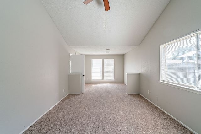 empty room featuring baseboards, a ceiling fan, a textured ceiling, and light carpet