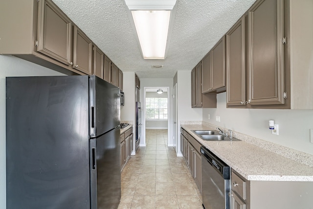 kitchen with a textured ceiling, stainless steel dishwasher, a sink, light countertops, and freestanding refrigerator