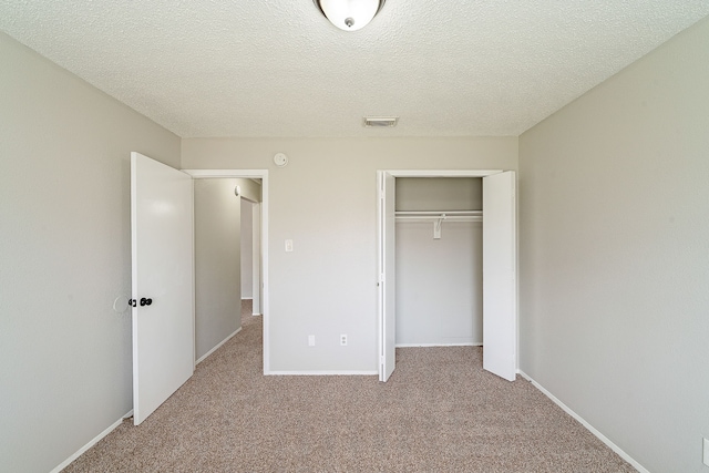unfurnished bedroom with a closet, baseboards, carpet flooring, and visible vents