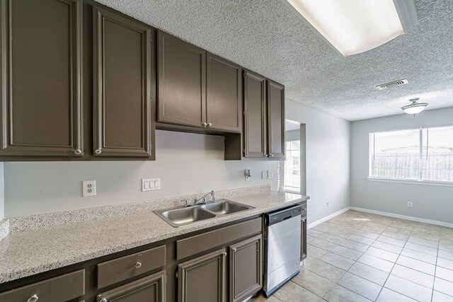 kitchen featuring light tile patterned flooring, a sink, dishwasher, light countertops, and visible vents