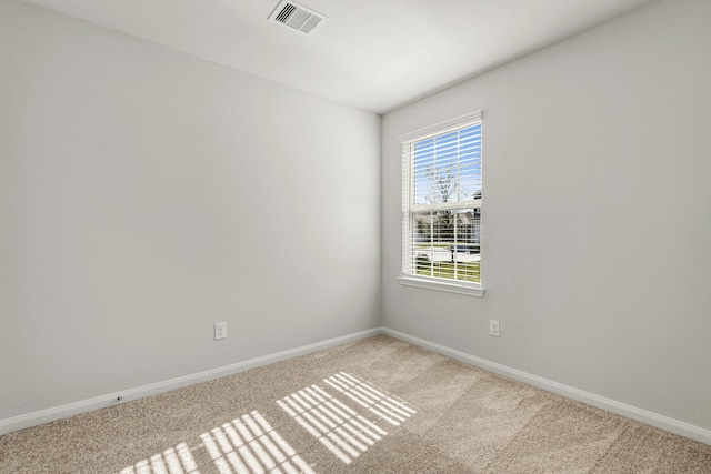 carpeted empty room with visible vents and baseboards