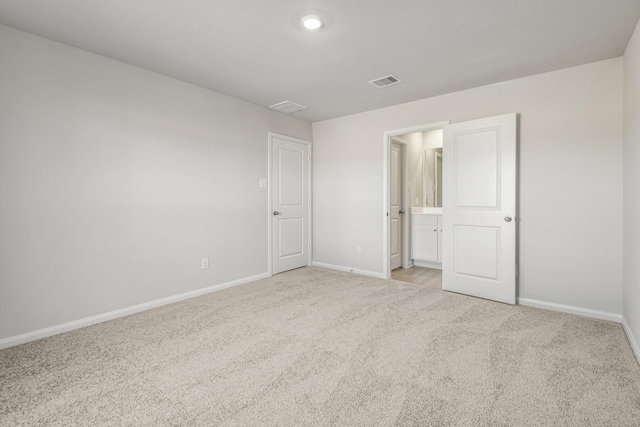 unfurnished bedroom with visible vents, baseboards, connected bathroom, and carpet floors