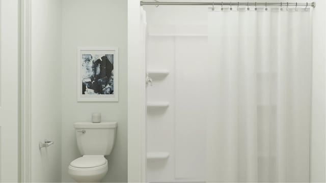 full bath featuring toilet and a shower with shower curtain