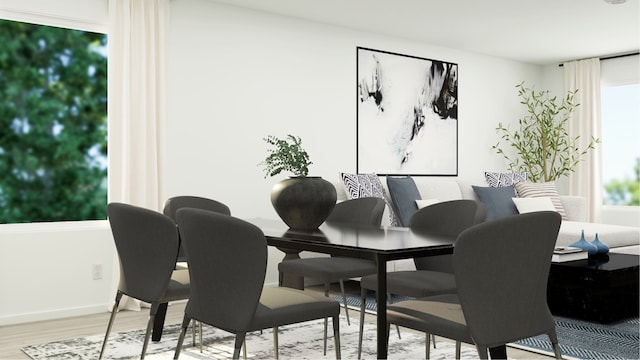 dining space with light wood-style flooring and baseboards