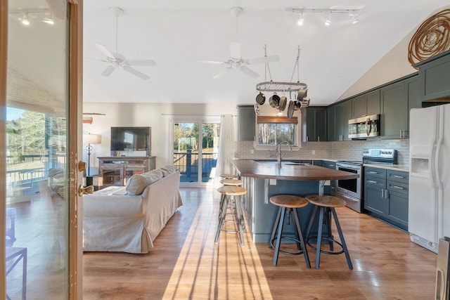 1222 Harts Creek Rd, Trinity, TX 75862 - kitchen featuring a breakfast bar, backsplash, appliances with stainless steel finishes, open floor plan, and ceiling fan