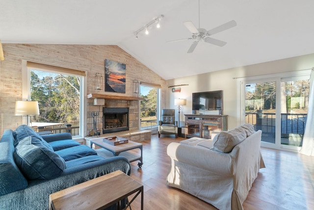 1222 Harts Creek Rd, Trinity, TX 75862 - living area with wood finished floors, ceiling fan, a stone fireplace, high vaulted ceiling, and rail lighting