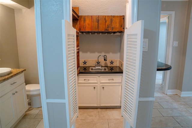 full bathroom featuring toilet, vanity, and tile patterned floors