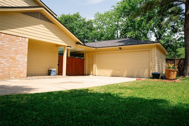 exterior space with concrete driveway, fence, a lawn, and a garage