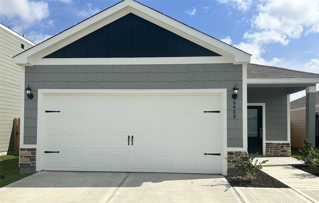 6408 Summer Pass Dr, Houston, TX 77048 - exterior space featuring an attached garage, stone siding, concrete driveway, and a shingled roof
