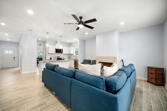 living room featuring baseboards, wood finish floors, recessed lighting, and ceiling fan