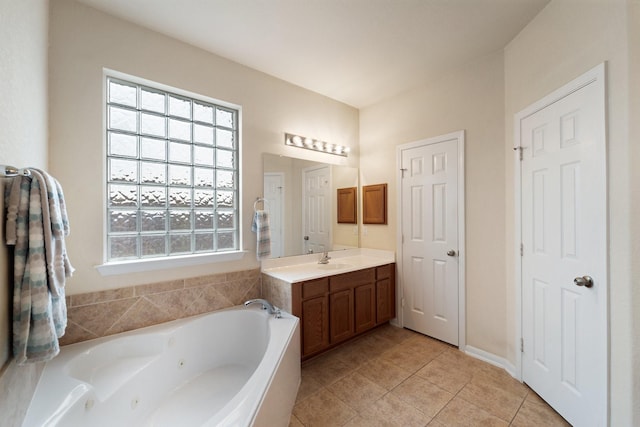 full bathroom featuring vanity, a tub with jets, tile patterned flooring, and plenty of natural light