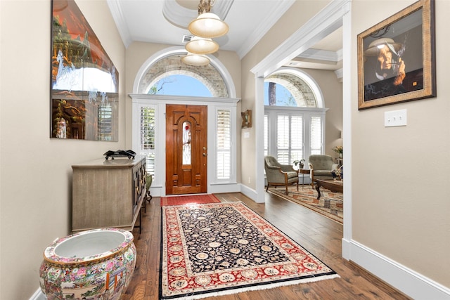 entryway with hardwood / wood-style flooring, baseboards, and crown molding
