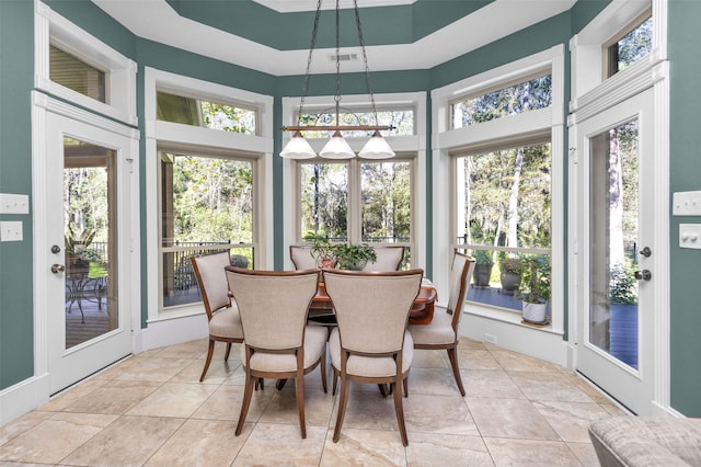 sunroom with french doors, a towering ceiling, and visible vents