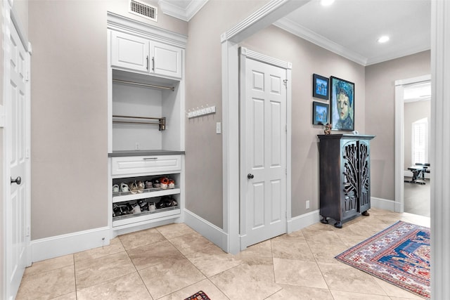 hallway with visible vents, baseboards, and ornamental molding