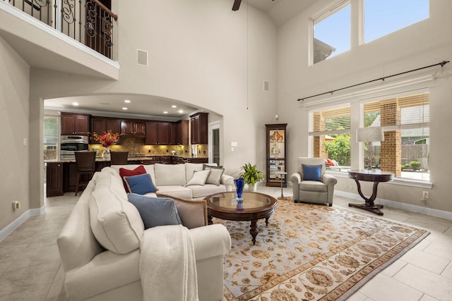 24636 Hosford Meadows Dr, Porter, TX 77365 - living area with arched walkways, a high ceiling, baseboards, and light tile patterned floors