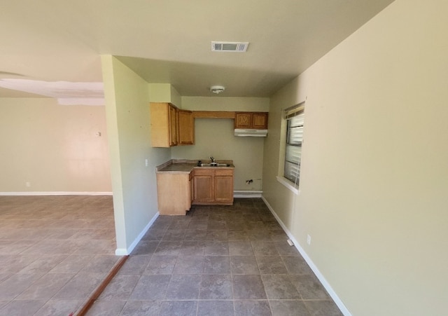 6710 Fairwood Rd, Hitchcock, TX 77563 - kitchen featuring stone finish floor, visible vents, baseboards, and a sink