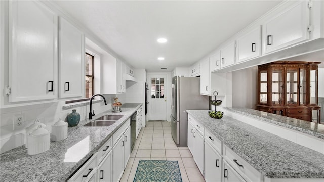 9831 Sagequeen Dr, Houston, TX 77089 - kitchen with a sink, light tile patterned floors, dishwasher, white cabinetry, and freestanding refrigerator