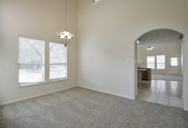 203 Annatto Ln, Crosby, TX 77532 - empty room with light colored carpet, arched walkways, a chandelier, baseboards, and a high ceiling