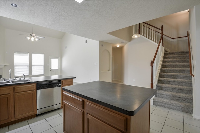 203 Annatto Ln, Crosby, TX 77532 - kitchen with stainless steel dishwasher, dark countertops, light tile patterned floors, vaulted ceiling, and a textured ceiling