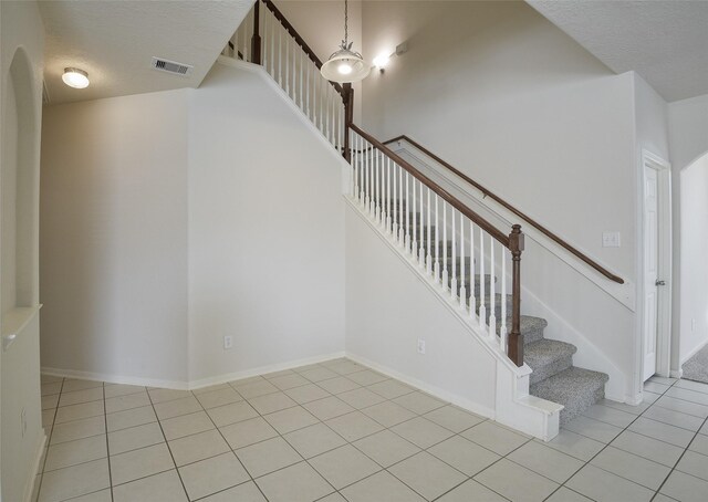 203 Annatto Ln, Crosby, TX 77532 - stairway featuring tile patterned floors, a textured ceiling, and baseboards