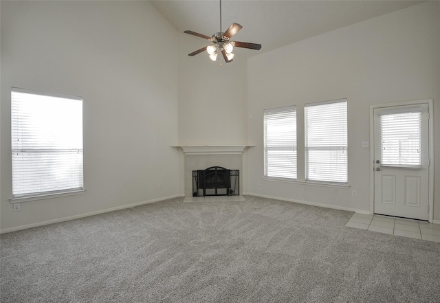 203 Annatto Ln, Crosby, TX 77532 - unfurnished living room with high vaulted ceiling, carpet flooring, ceiling fan, a tile fireplace, and healthy amount of natural light