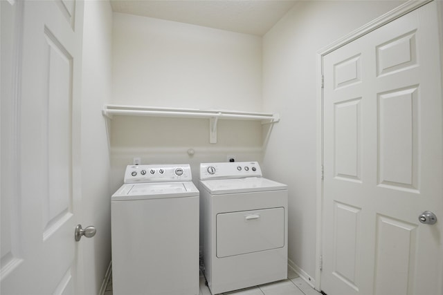 203 Annatto Ln, Crosby, TX 77532 - laundry area featuring washer and dryer, light tile patterned floors, and baseboards