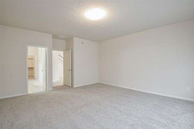 203 Annatto Ln, Crosby, TX 77532 - unfurnished bedroom featuring light carpet, a textured ceiling, and baseboards