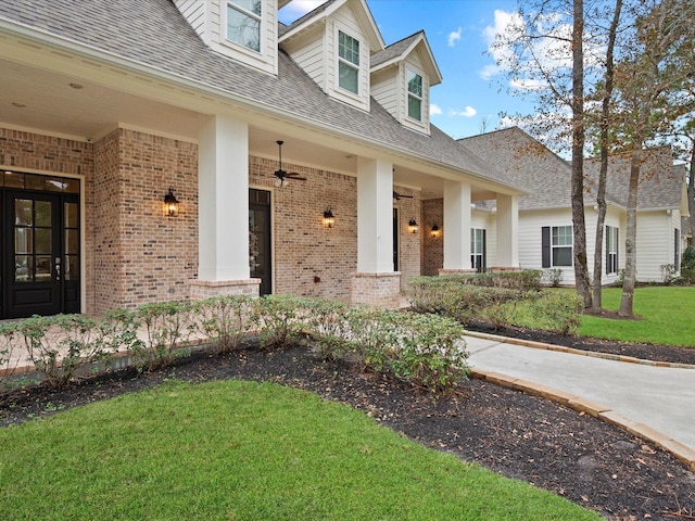 10539 Crestwater Cir, Magnolia, TX 77354 - property entrance featuring brick siding, ceiling fan, a yard, and roof with shingles