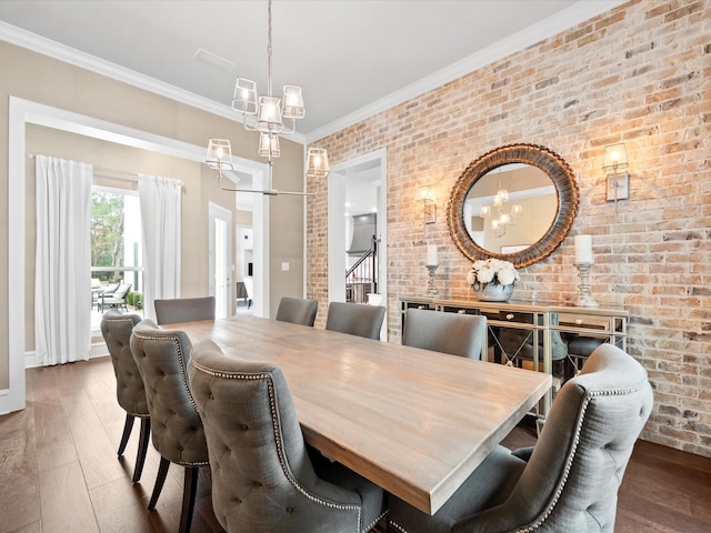 10539 Crestwater Cir, Magnolia, TX 77354 - dining space featuring hardwood / wood-style flooring, a chandelier, crown molding, brick wall, and baseboards