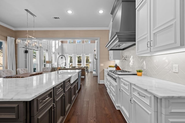 10539 Crestwater Cir, Magnolia, TX 77354 - kitchen with wall chimney range hood, a sink, appliances with stainless steel finishes, backsplash, and dark wood-style floors