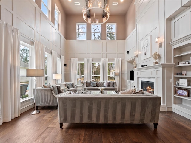 10539 Crestwater Cir, Magnolia, TX 77354 - living area with a fireplace, dark wood-type flooring, a towering ceiling, and a chandelier