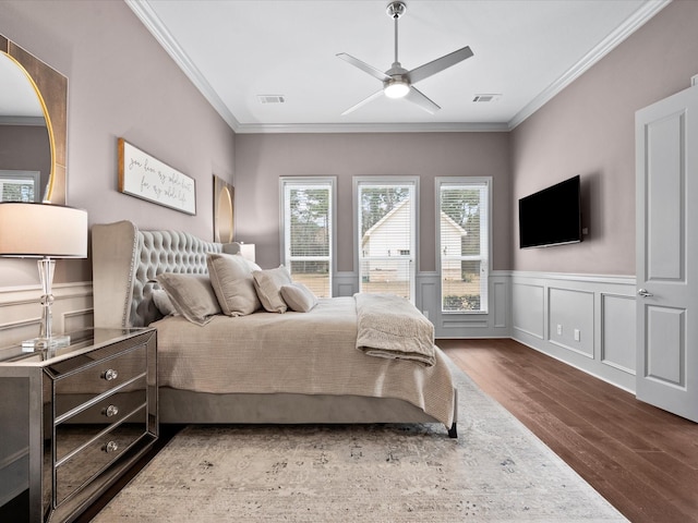 10539 Crestwater Cir, Magnolia, TX 77354 - bedroom with wood finished floors, ornamental molding, a wainscoted wall, ceiling fan, and a decorative wall