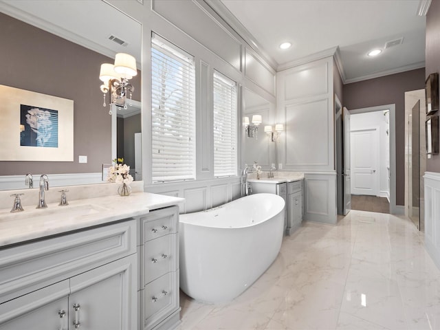 10539 Crestwater Cir, Magnolia, TX 77354 - full bath featuring crown molding, marble tiled flooring, a decorative wall, a freestanding tub, and two vanities