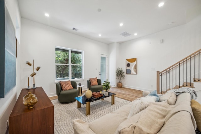 living area featuring recessed lighting, stairway, visible vents, and wood finished floors