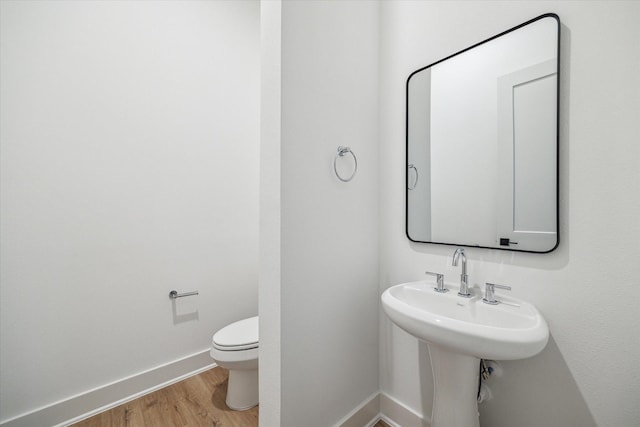 bathroom featuring baseboards, toilet, and wood finished floors
