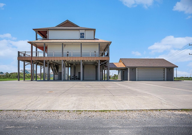 view of front of home featuring a carport, a standing seam roof, driveway, and metal roof
