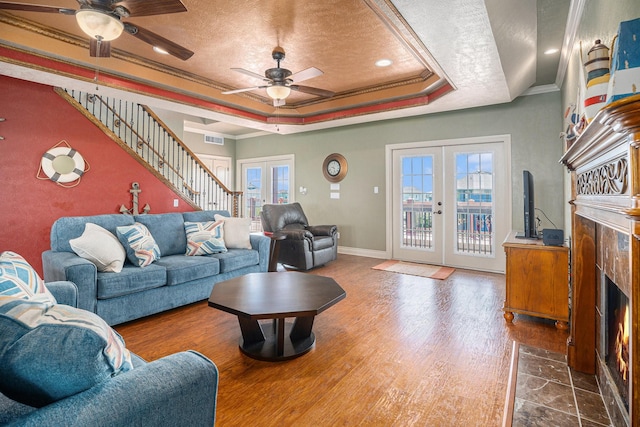 living area with french doors, ornamental molding, a wealth of natural light, and a ceiling fan