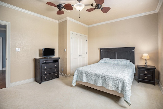 bedroom with a ceiling fan, ornamental molding, a closet, baseboards, and light colored carpet