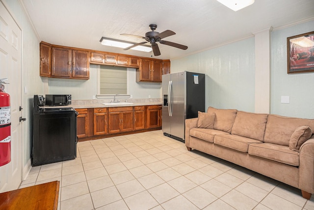 kitchen with light countertops, open floor plan, a sink, and black appliances
