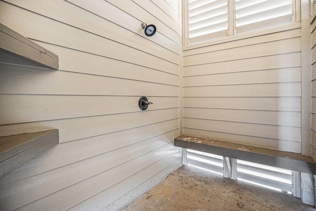 exterior space with unfinished concrete floors and wooden walls