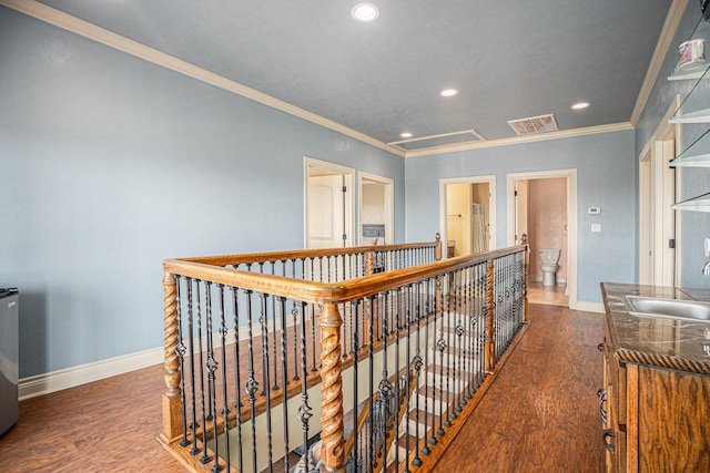 hall with baseboards, ornamental molding, a sink, and recessed lighting